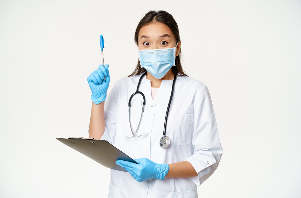 excited-female-doctor-asian-physician-holding-clipboard-raising-pen-up-found-solution-idea-standing-medical-face-mask-white-background (1)